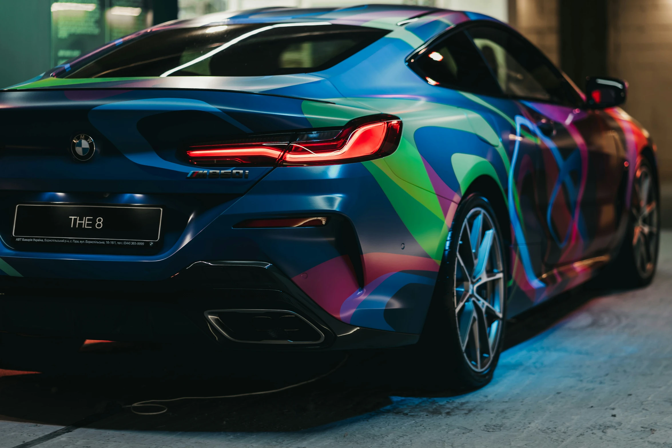 the front end of a bmw vehicle painted in a rainbow