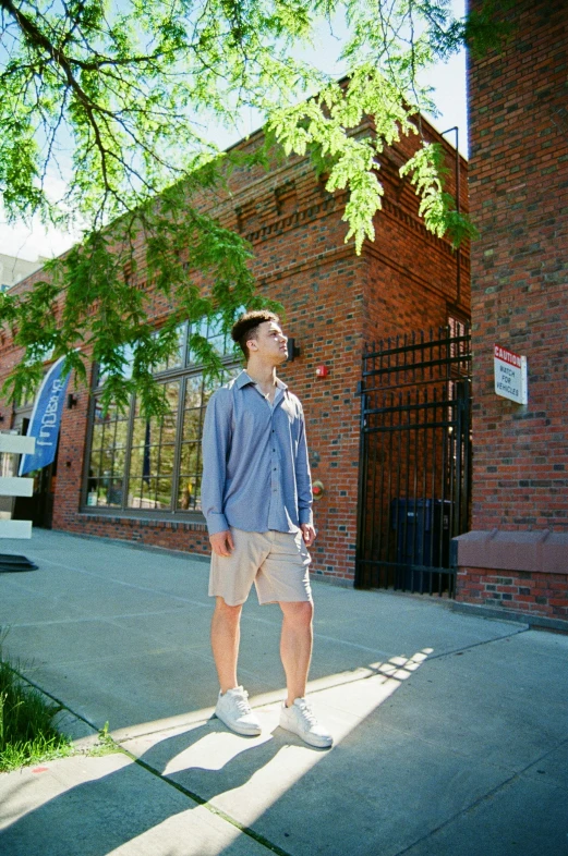 a man is standing on the sidewalk by a building