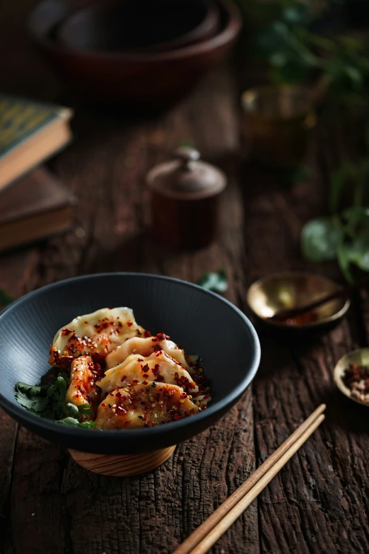 a bowl filled with food next to chop sticks