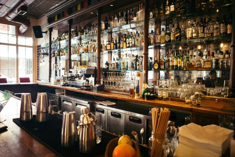 an old time bar with many bottles and glasses on the shelves