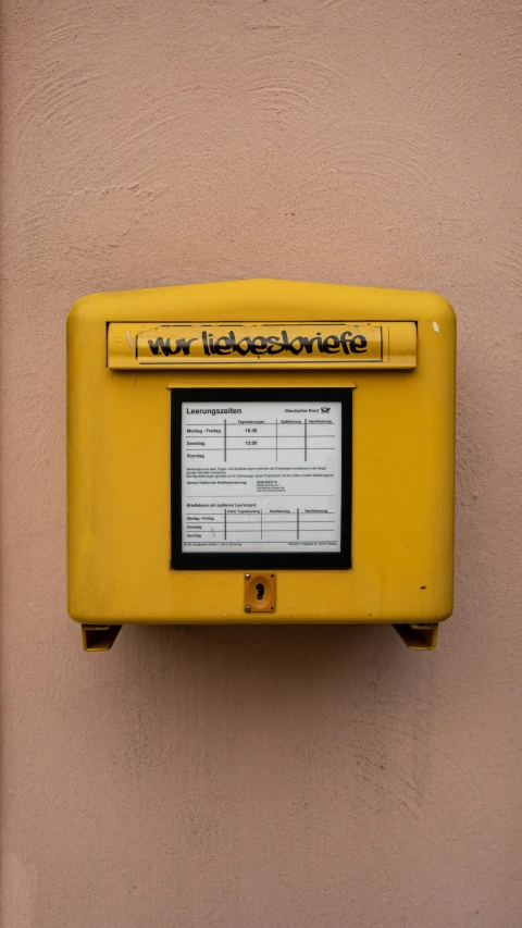 a yellow clock mounted to a wall near some beige walls