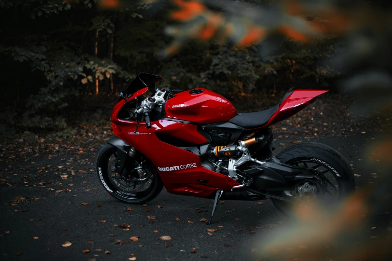 a very shiny red motorcycle parked by itself