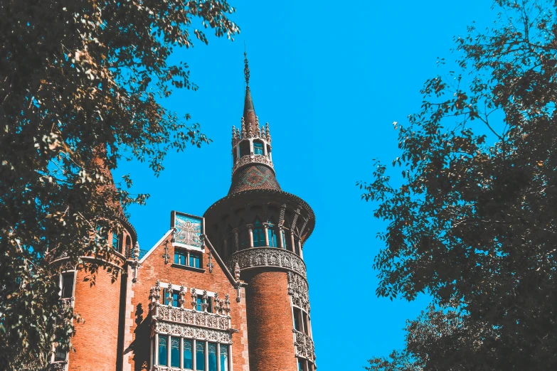 a building sits behind some trees and blue sky