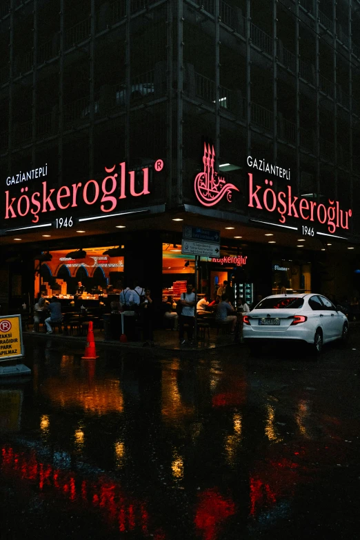 night scene, with wet pavement and shop building