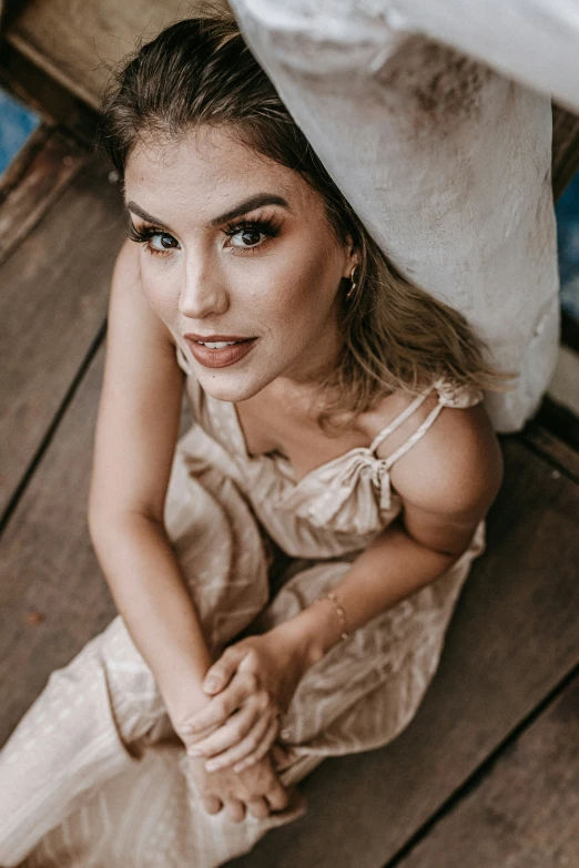 a woman sitting down on a wooden deck