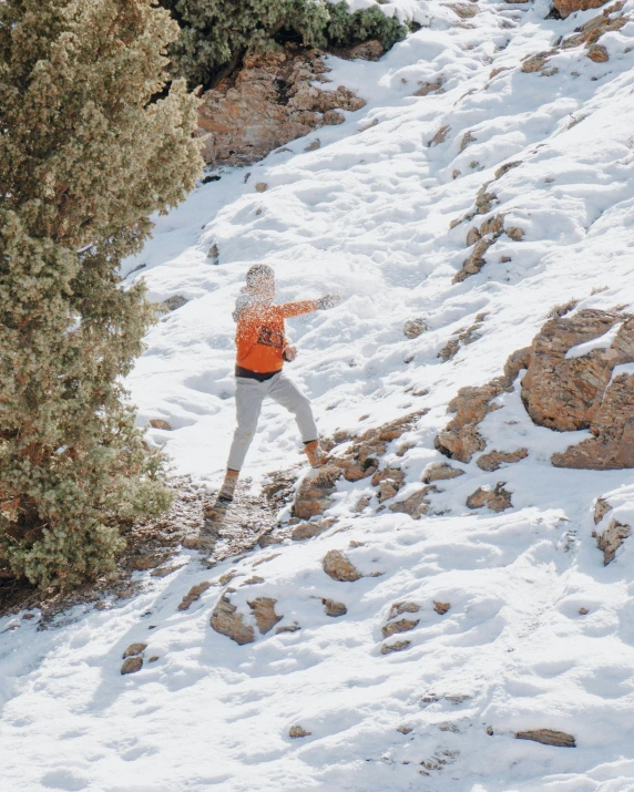 an orange and gray skier is headed down a snowy mountain