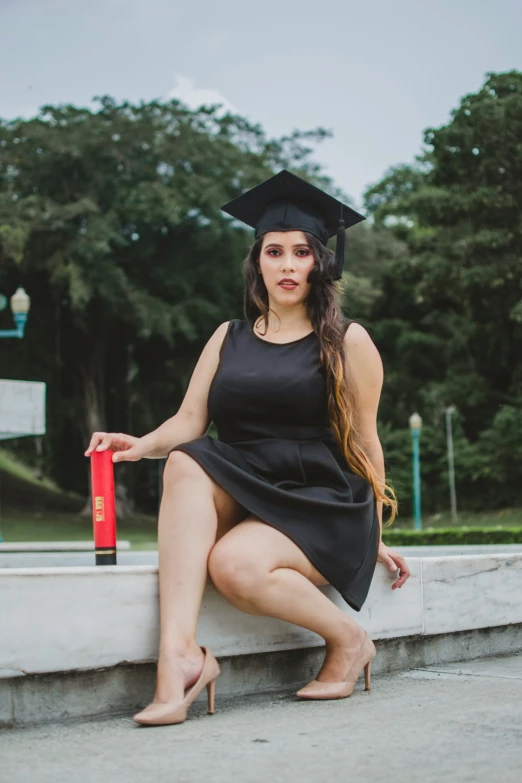 a woman posing in her graduation gown with her hands on her hips