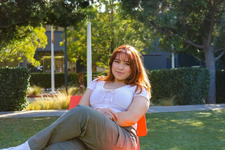 a woman sits on a chair in the grass