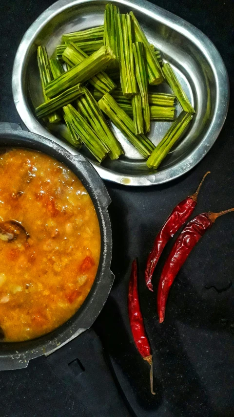 an empty metal pan and some vegetables sitting on a table