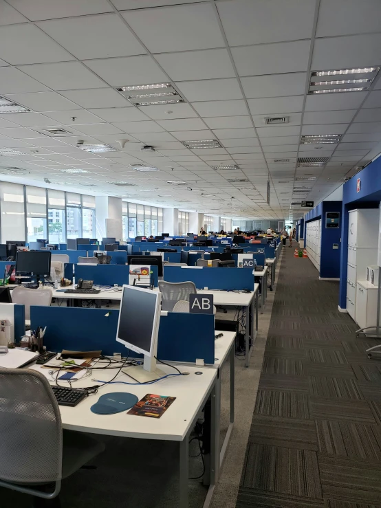 an office with several cubicles and blue desks