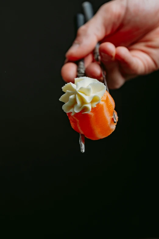 a hand holds a pastry on a spoon