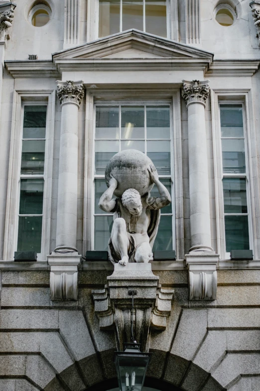 a statue on a stone building ledge