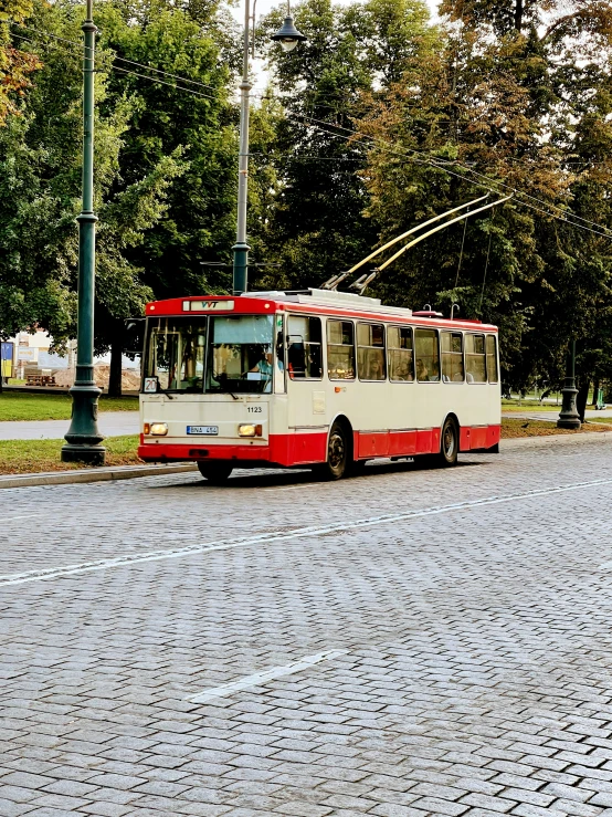 there is a red and white bus parked at a bus stop