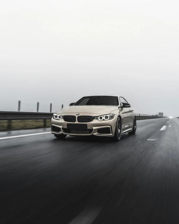 the front of a white bmw e90 sedan driving down the highway