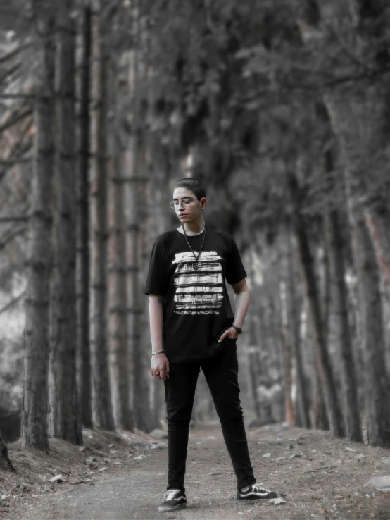 a man with eyepaint stands on a road in front of trees