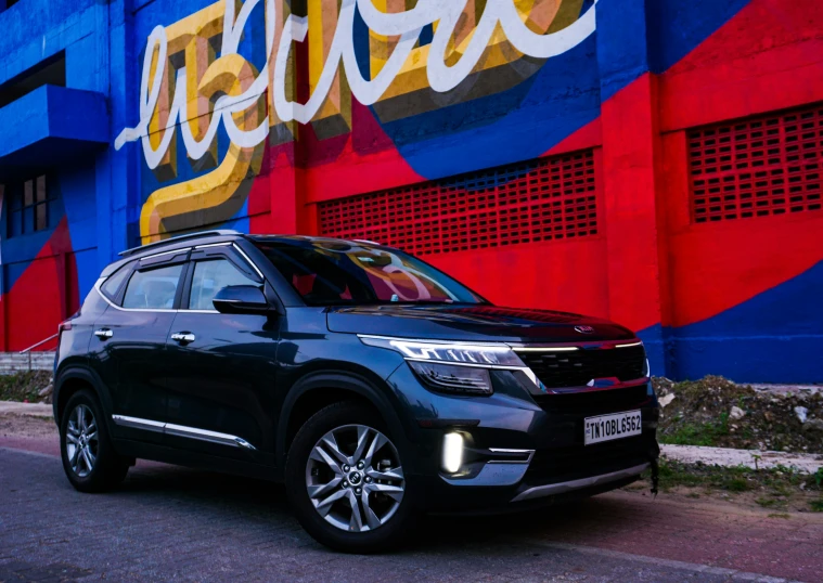 a black suv in front of a brightly painted wall