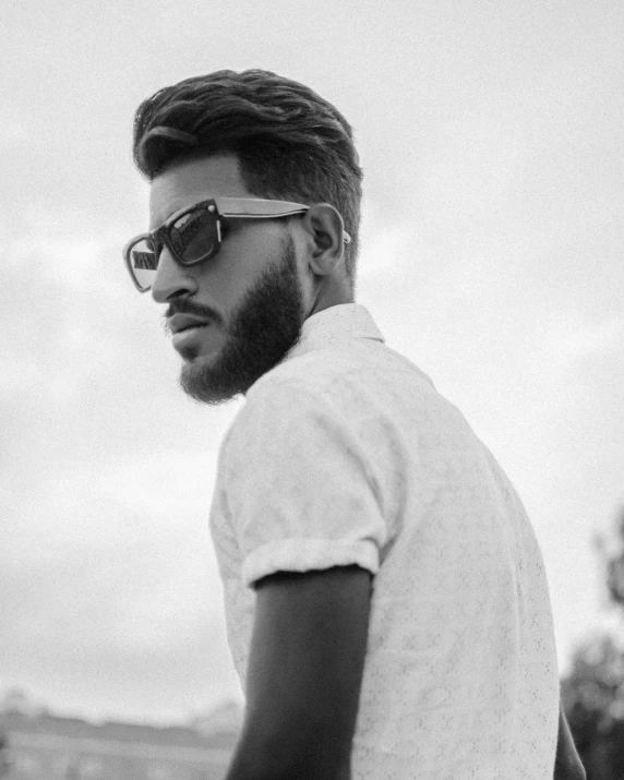 a black and white pograph of a young man wearing sunglasses