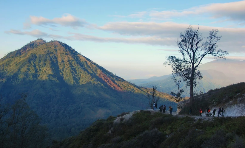 a group of people walking on a trail in the mountains