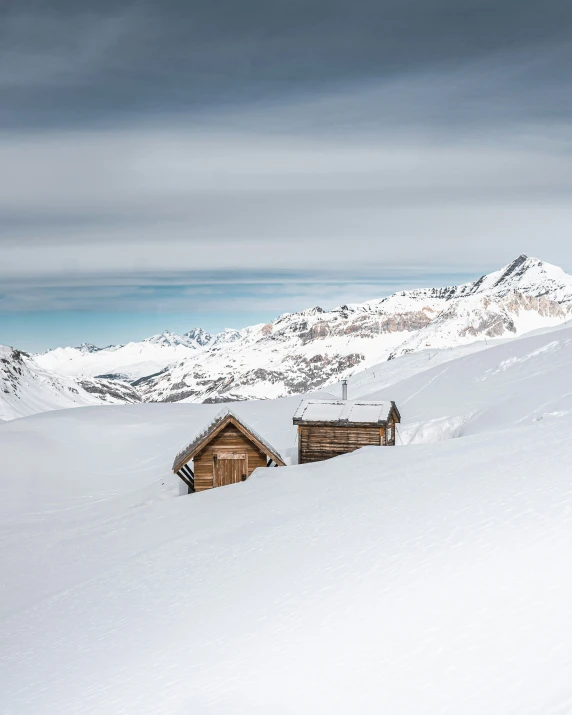 a large mountain with a number of small buildings in the snow