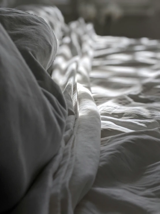 a bed with white sheets and a blanket