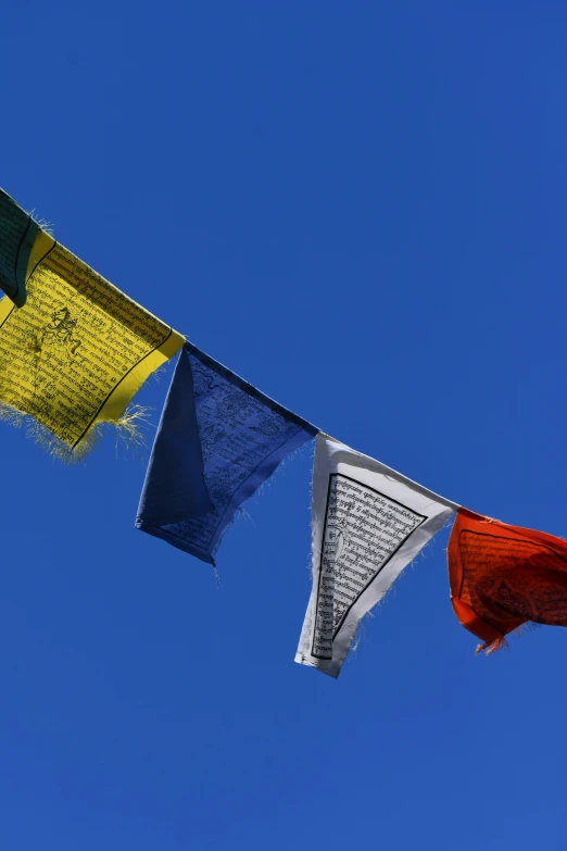 several colorful pieces of material hanging in the sky