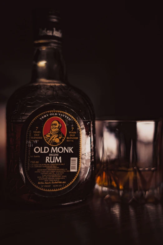 an old monk rum is next to an empty glass