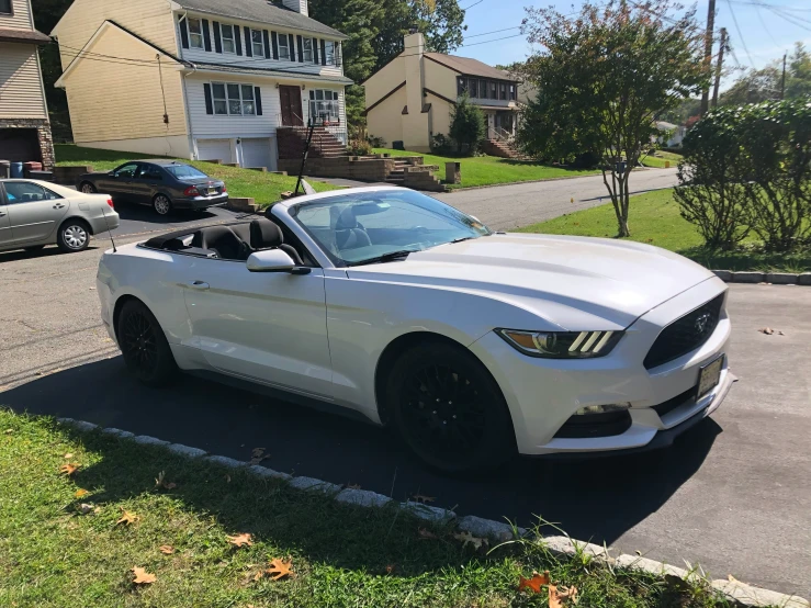 the white mustang parked in front of a house