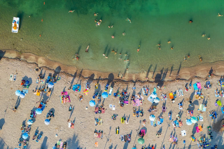 people sitting in lawn chairs on a beach