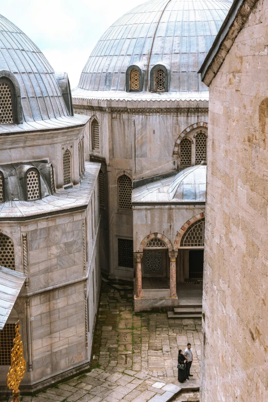 the view from an open stone - walled building overlooking a courtyard