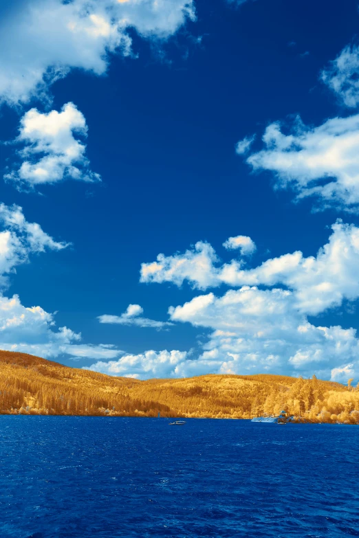 there is a blue sky and clouds above a body of water