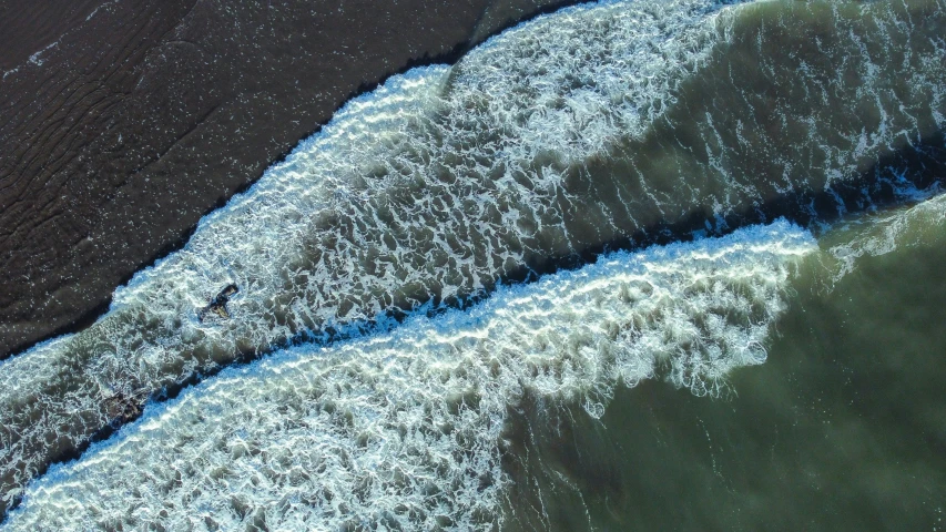 a large expanse of water with small waves coming up from the shore