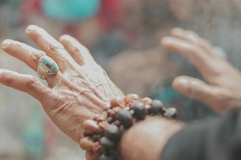 the palm of a woman is holding the beads