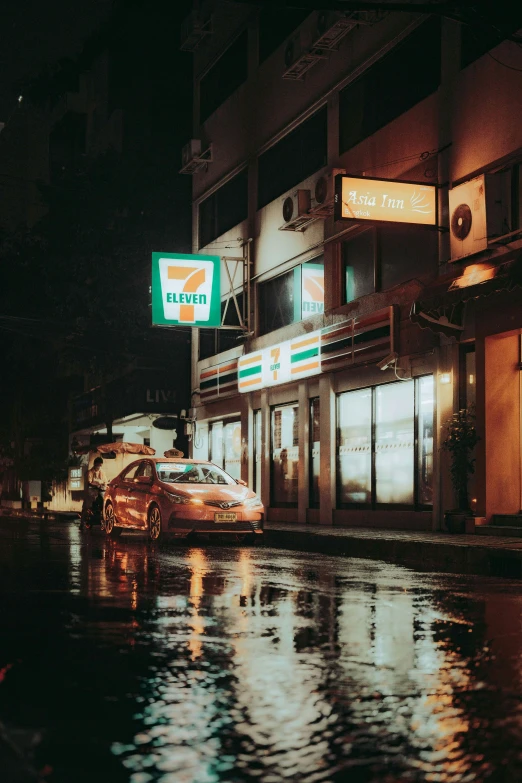 a city street that has a sign on it in the rain