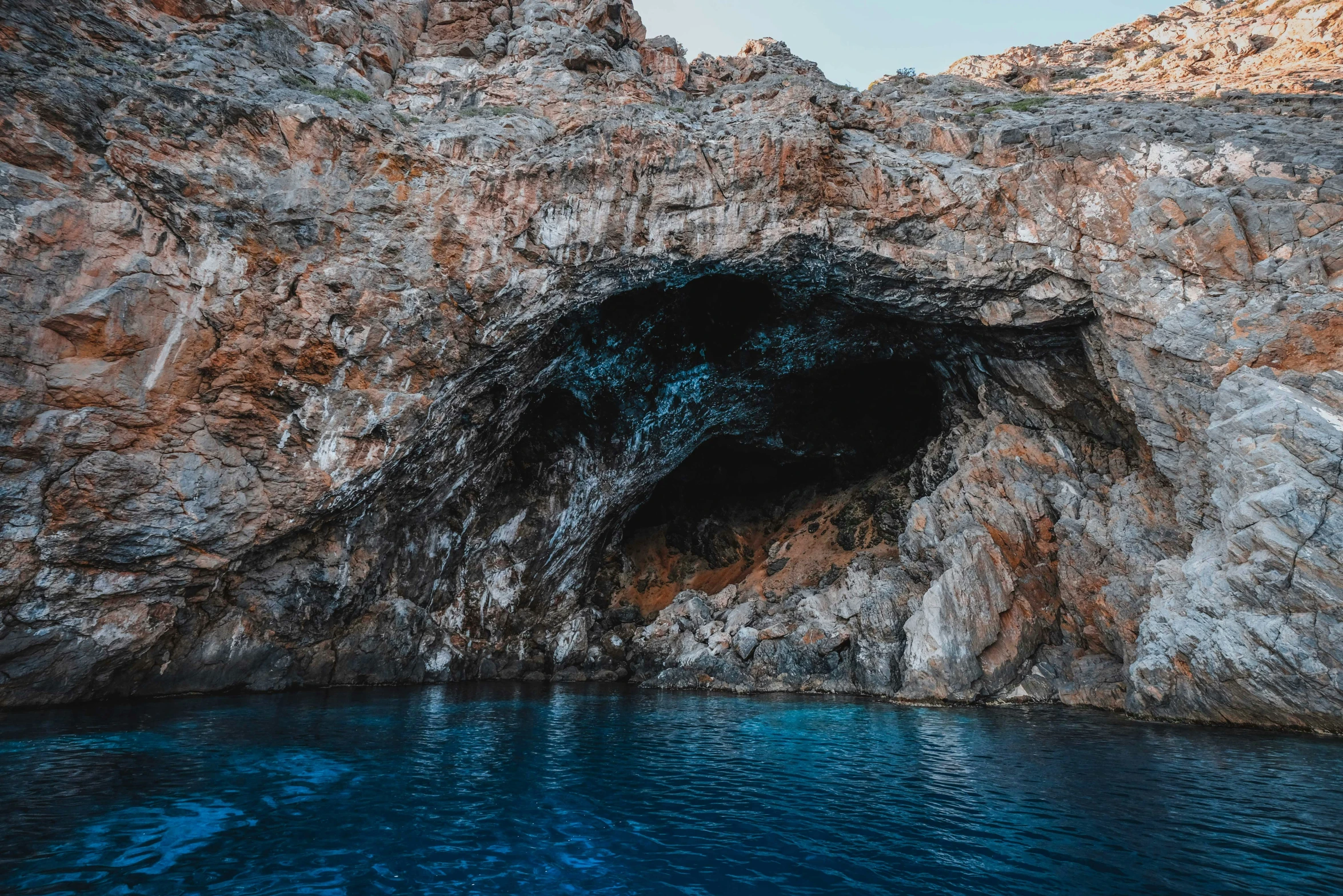 a cave entrance at the bottom of a cliff