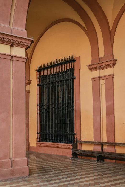 a large black gate is next to a red and tan building