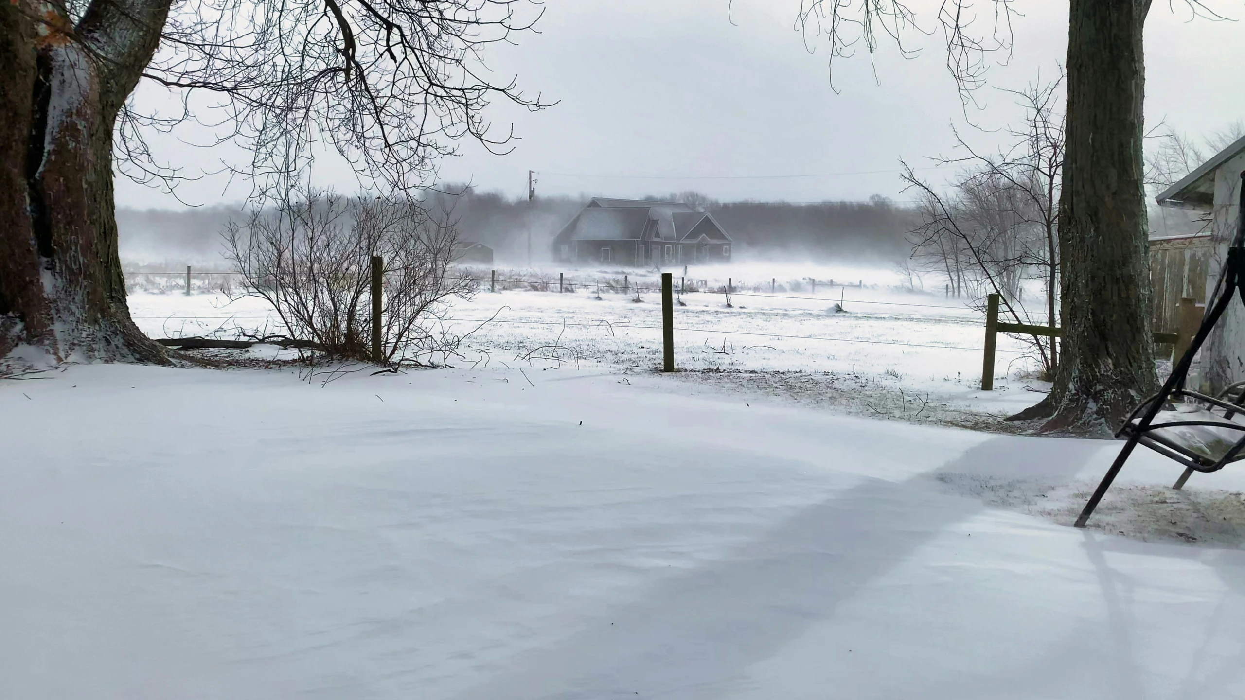 a bench in the middle of a snow covered yard