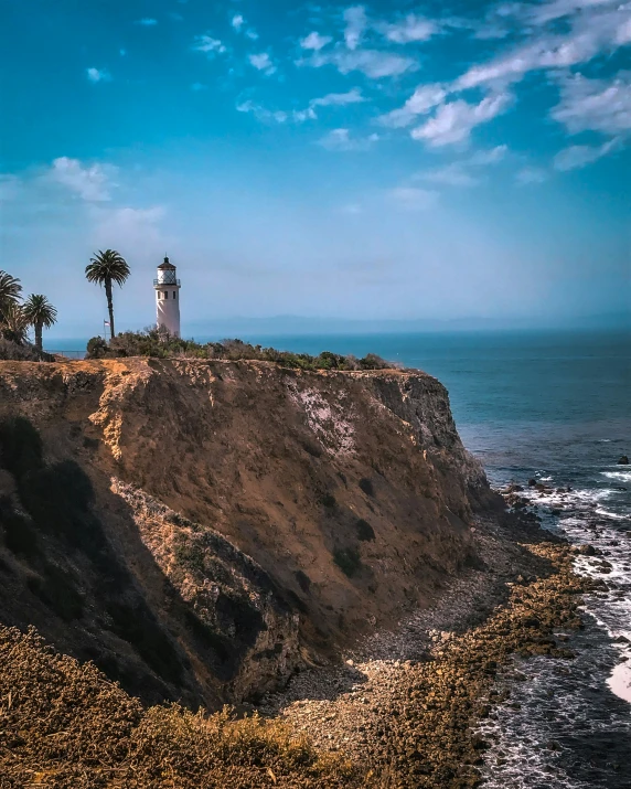 the lighthouse is built on top of a cliff near the water