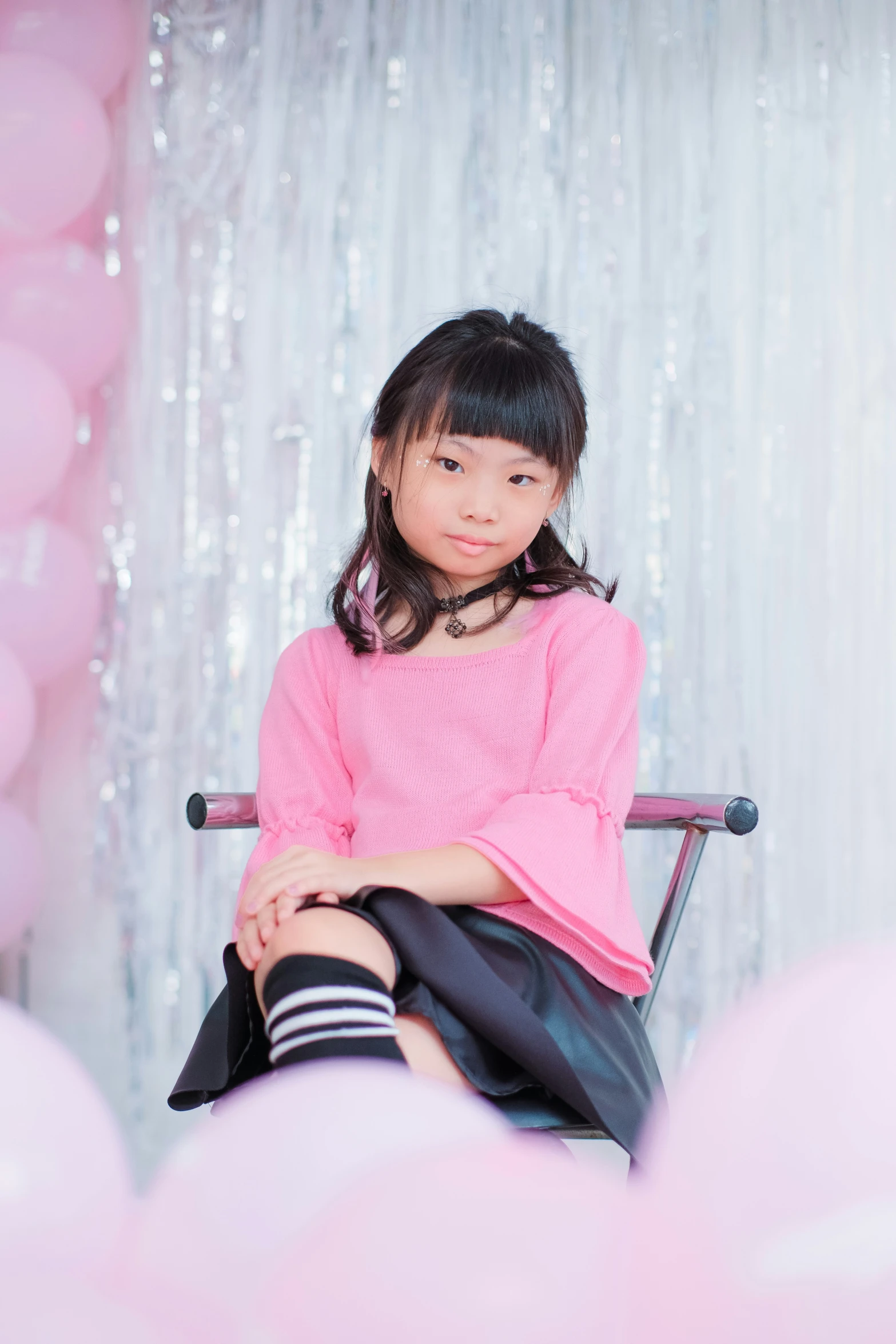 an asian girl sitting on a chair with her foot up