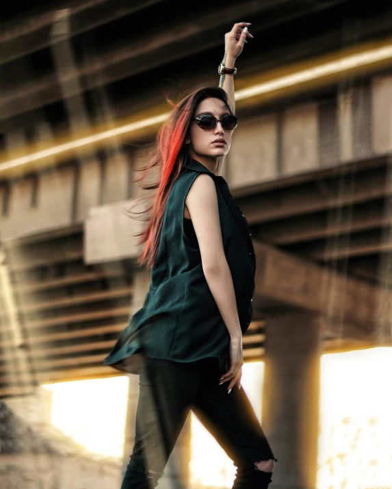 a woman with red hair and black clothing standing next to a building