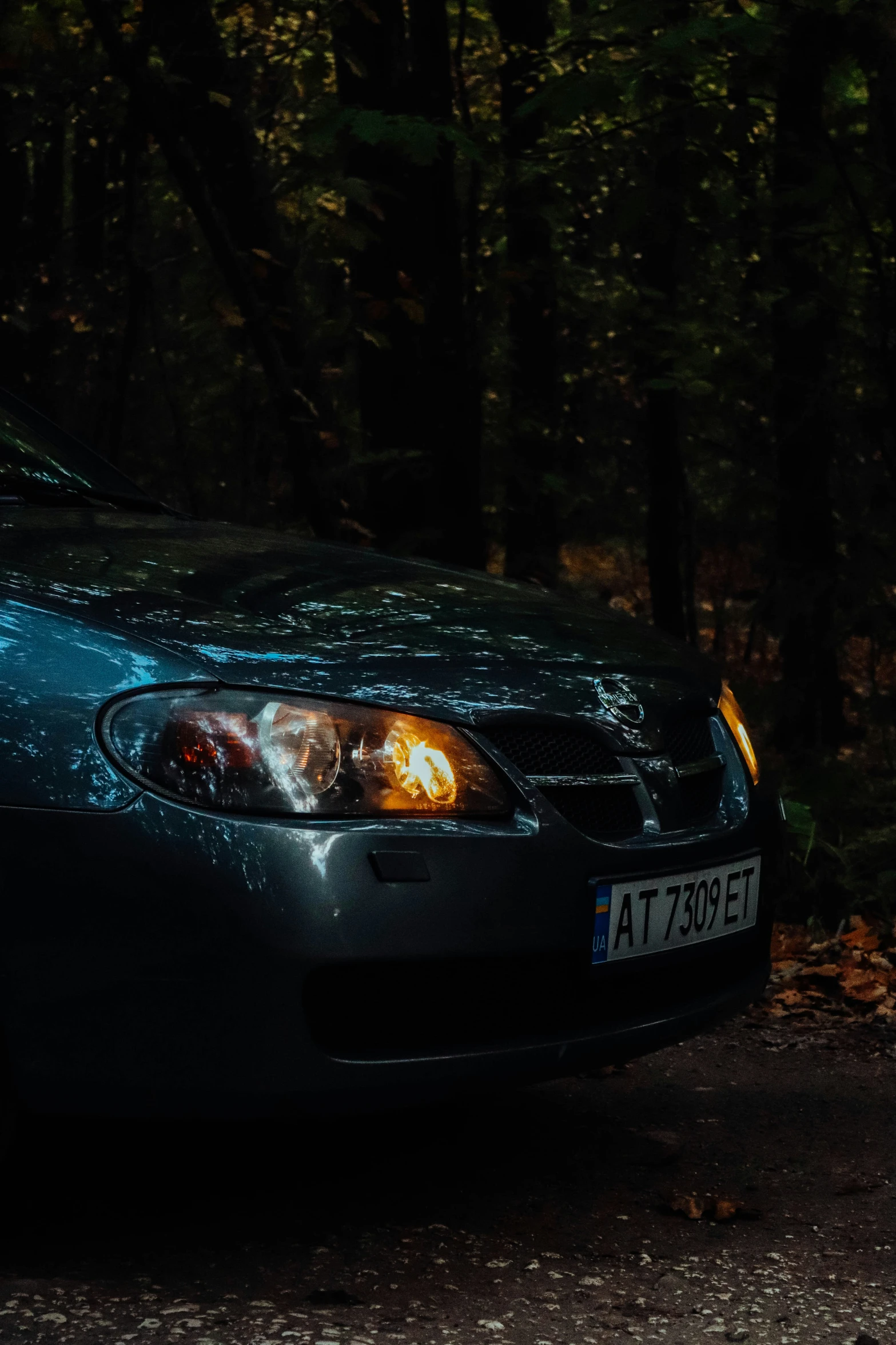 the front end of a blue car with an orange spot in it