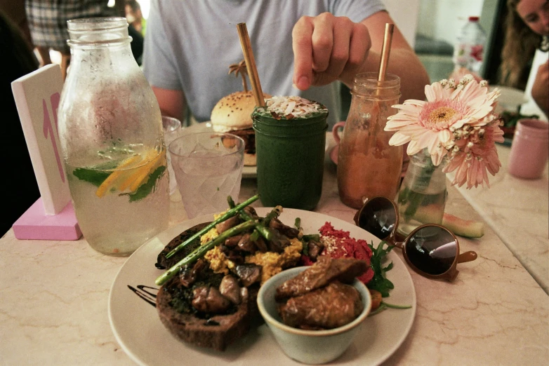 the person is sitting at the table having a plate of food