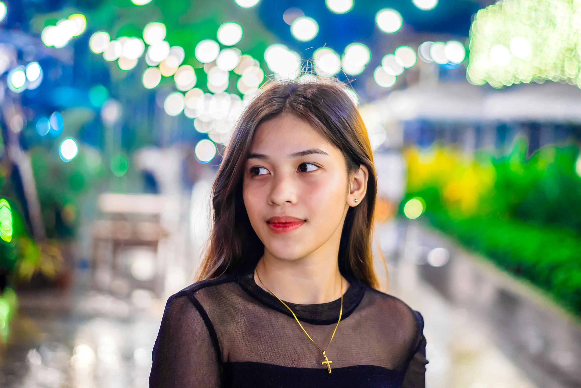 the young woman is posing in front of green lights