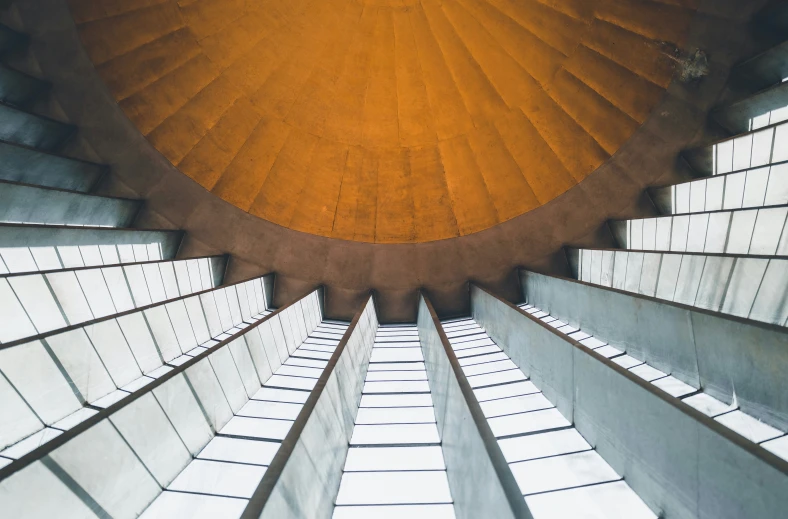 the top of a staircase with a giant metal object above it