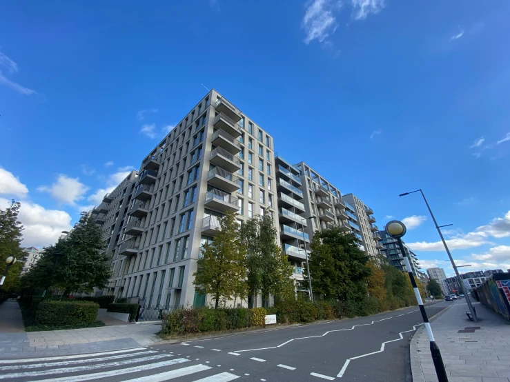 large building surrounded by trees and a few other buildings on the road