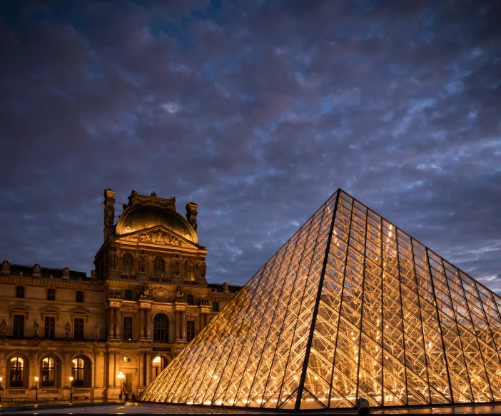 the large pyramid is lit up in front of the building