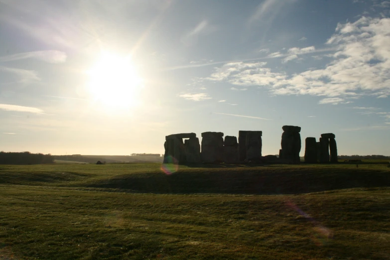 the sun is shining behind an ancient monument