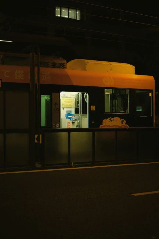 a large bus stop at night with an empty bus in the background