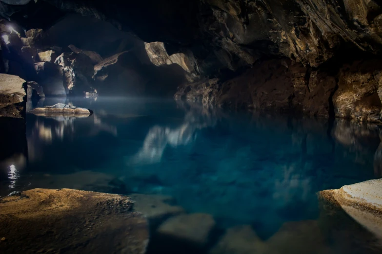 water in a blue cave with large cliffs