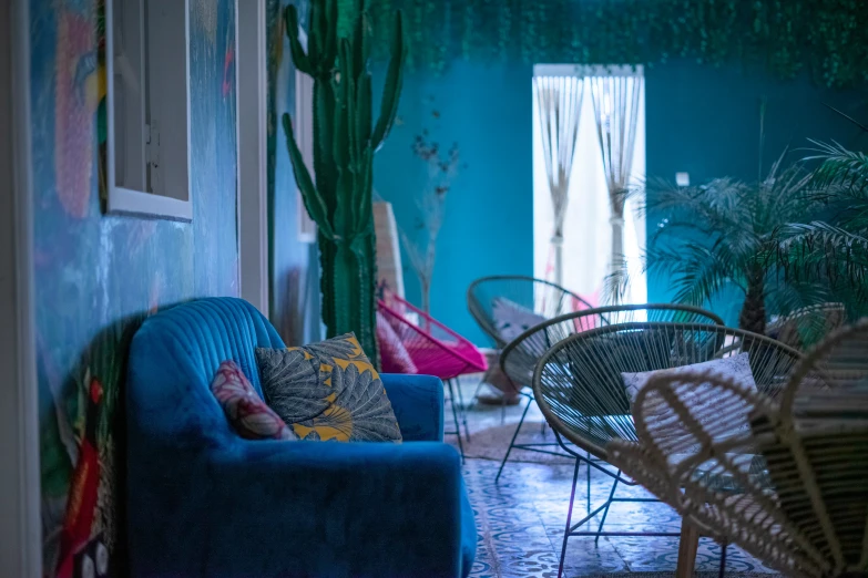 two sofas in a living room with cactus wall paper