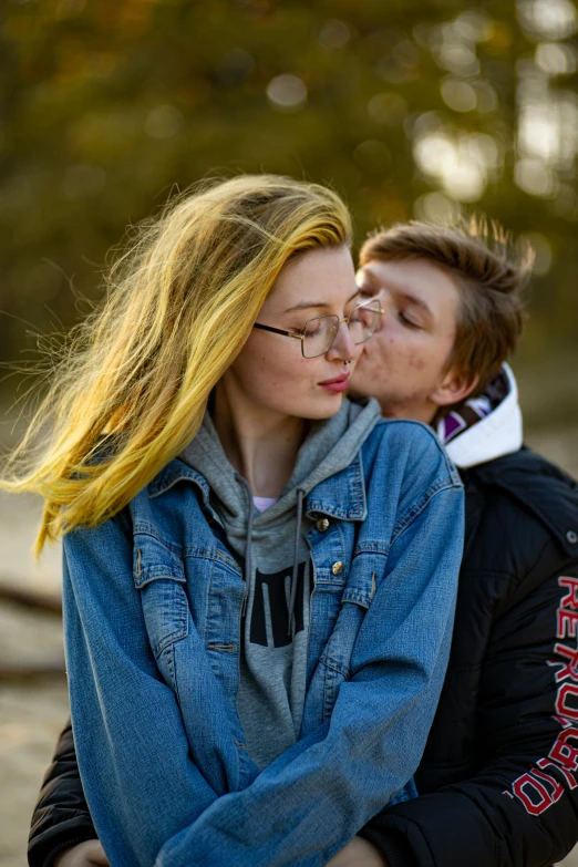 a man kisses a woman's face in a park